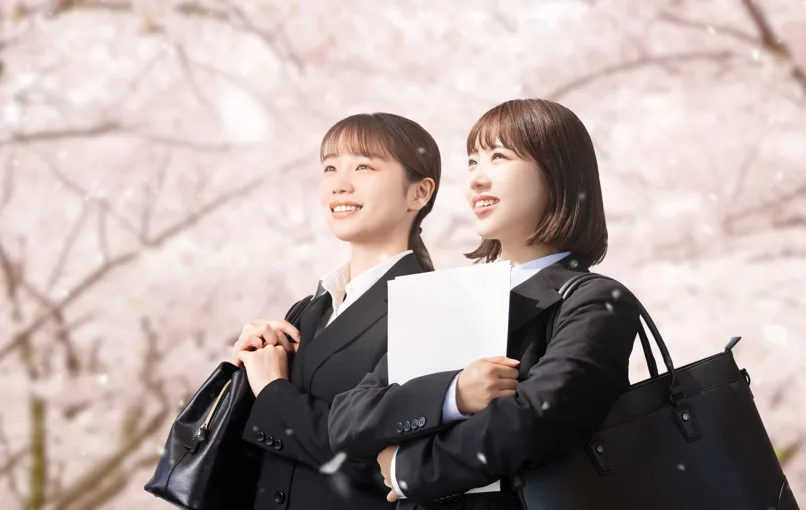 桜並木の下を歩く新卒の薬剤師